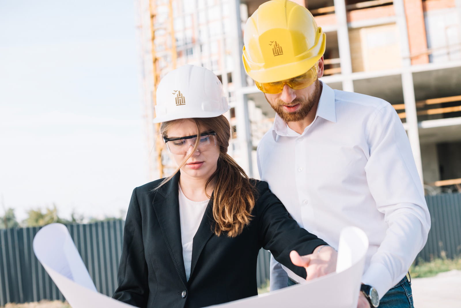 Construction engineers reviewing building plans at a construction site for project development